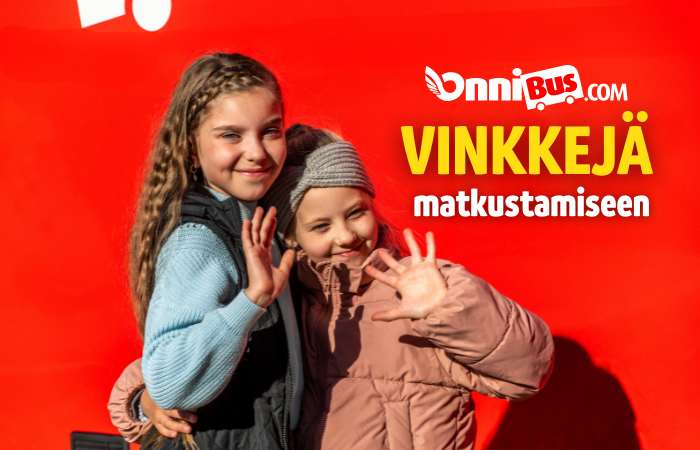 Iloisia matkustajia OnniBusin edessä heiluttamassa kättä
